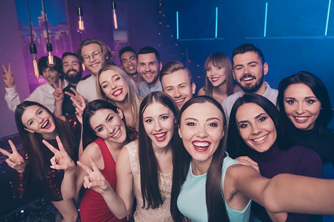 Self-portrait of nice-looking attractive glamorous lovely shine pretty cheerful, positive glad funny coquettish ladies and guys having fun rest relax showing v-sign at luxury fogged nightclub